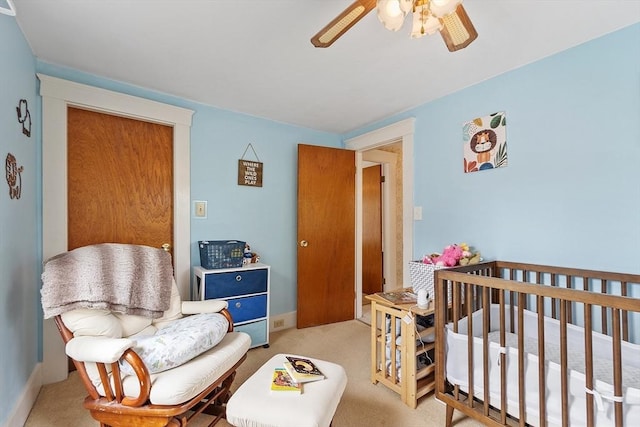 bedroom with light carpet, a ceiling fan, and baseboards