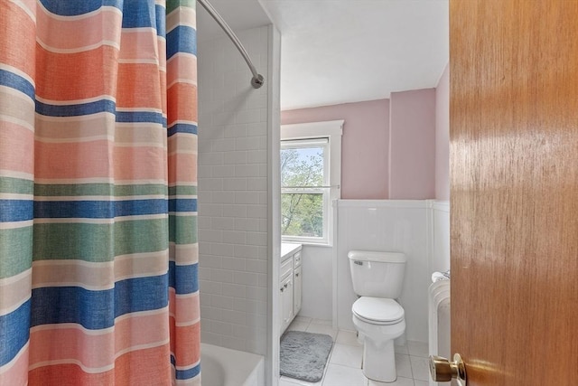 bathroom with tile patterned floors, toilet, and wainscoting