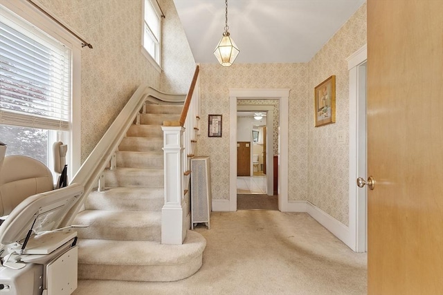 stairs featuring wallpapered walls, carpet flooring, lofted ceiling, and baseboards