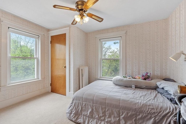 bedroom featuring radiator, wallpapered walls, carpet flooring, and ceiling fan