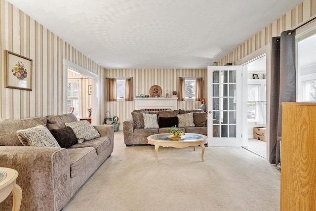 carpeted living room featuring wallpapered walls and healthy amount of natural light