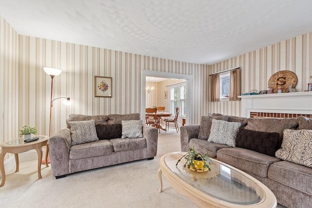 living room with wallpapered walls, light carpet, and a chandelier