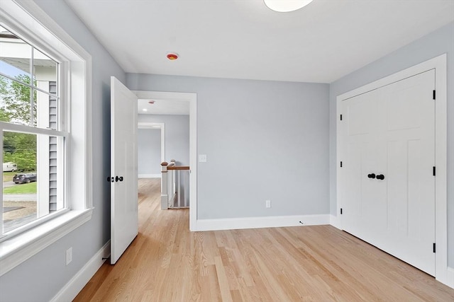192 Tahattawan, Littleton, MA 01460 - unfurnished bedroom with light wood-style flooring, baseboards, and a closet