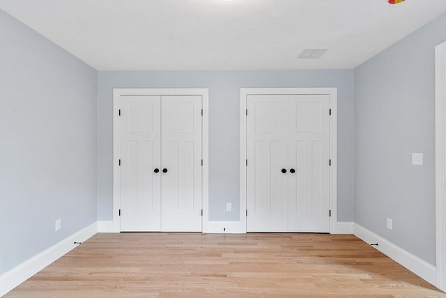 192 Tahattawan, Littleton, MA 01460 - unfurnished bedroom featuring two closets, light wood-style flooring, and baseboards