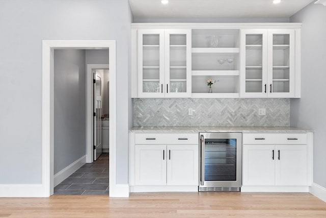 192 Tahattawan, Littleton, MA 01460 - indoor dry bar with beverage cooler, light wood-type flooring, backsplash, baseboards, and recessed lighting