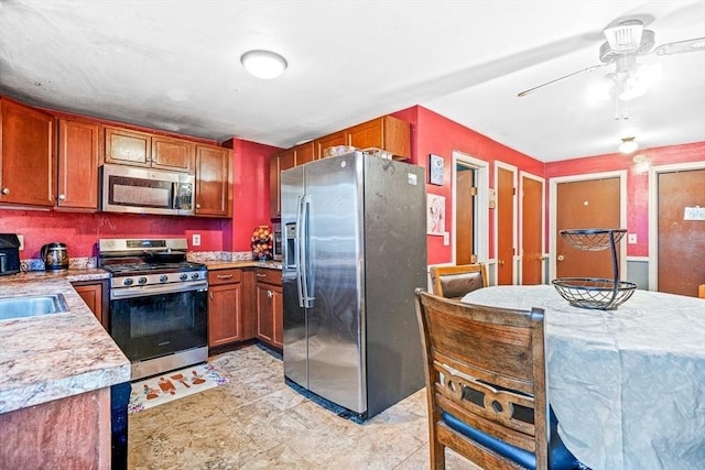 kitchen with stainless steel appliances, brown cabinets, ceiling fan, and light countertops