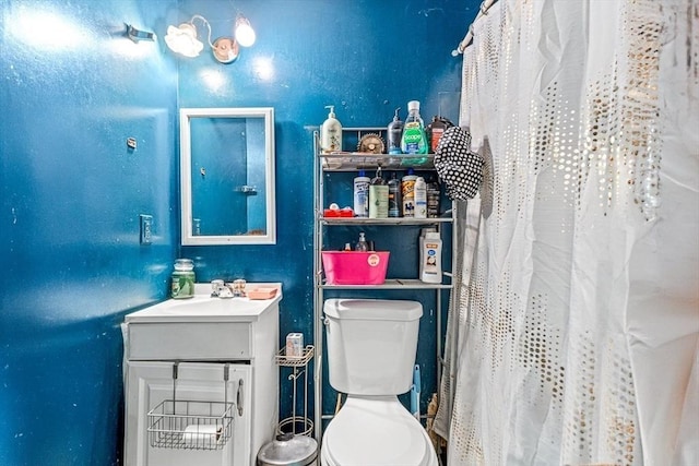 bathroom featuring a shower with shower curtain, toilet, and vanity