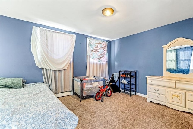 carpeted bedroom featuring multiple windows, baseboards, and baseboard heating