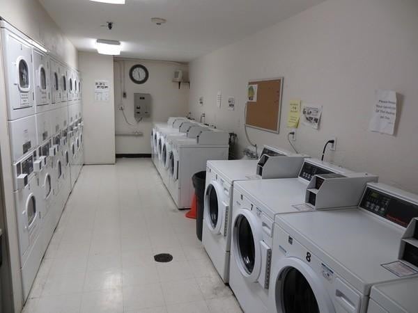 community laundry room with stacked washing machine and dryer, washer and clothes dryer, and light flooring