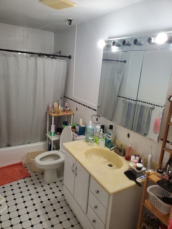 bathroom with shower / bath combo, toilet, and vanity