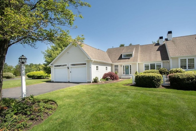 view of front facade with aphalt driveway, an attached garage, and a front yard