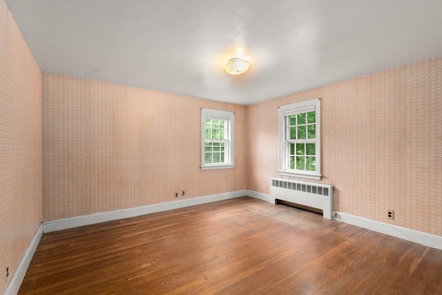 65 Kirkstall Rd, Newton, MA 02460 - unfurnished room featuring radiator, wallpapered walls, and wood-type flooring
