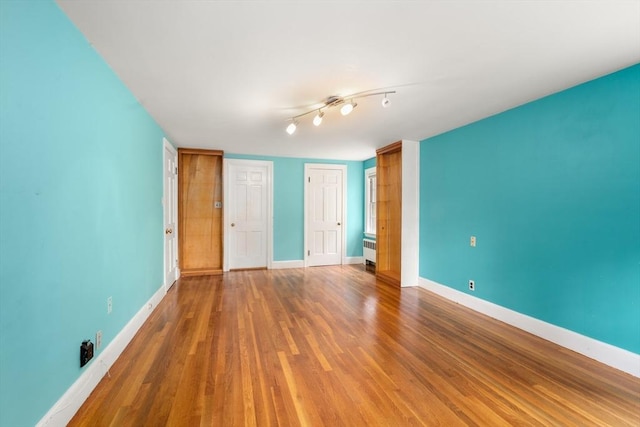 65 Kirkstall Rd, Newton, MA 02460 - unfurnished bedroom featuring radiator heating unit, wood finished floors, and a closet