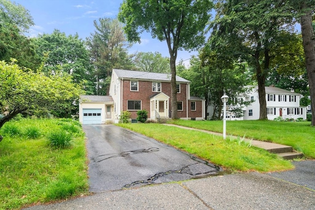 65 Kirkstall Rd, Newton, MA 02460 - colonial-style house featuring a garage, brick siding, asphalt driveway, and a front yard