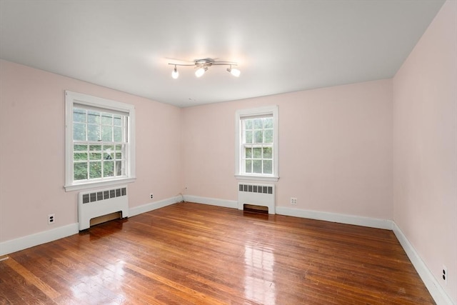 65 Kirkstall Rd, Newton, MA 02460 - spare room featuring radiator heating unit, plenty of natural light, and wood finished floors