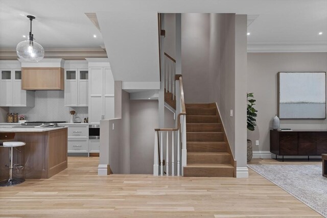 17 Alveston St Unit A, Boston, MA 02130 - kitchen featuring ornamental molding, glass insert cabinets, white cabinetry, light wood-style floors, and decorative backsplash
