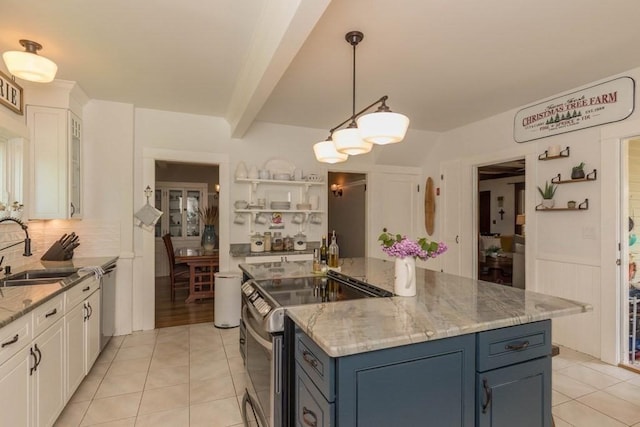 kitchen featuring appliances with stainless steel finishes, blue cabinets, a sink, and light tile patterned floors