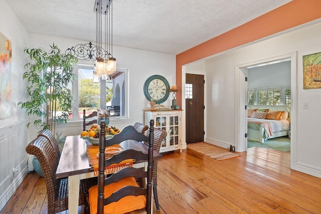 dining room featuring an inviting chandelier, baseboards, and hardwood / wood-style flooring