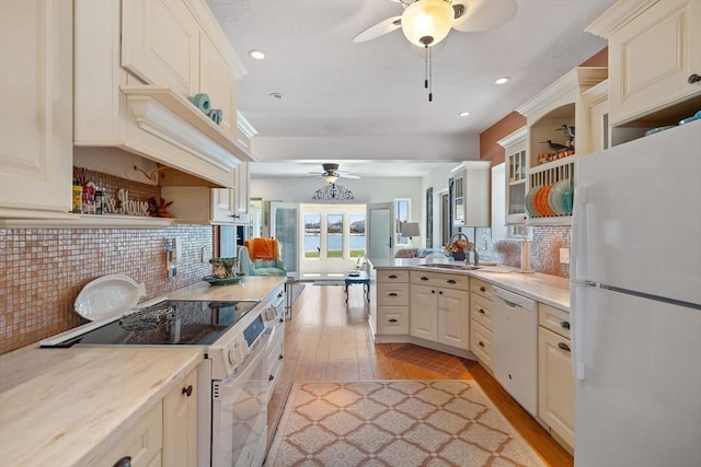 kitchen featuring a ceiling fan, white appliances, light wood finished floors, a sink, and light countertops