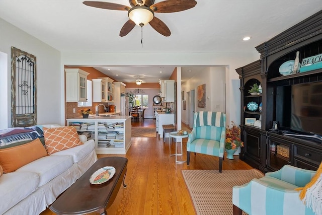 living room featuring a ceiling fan, light wood-style floors, and recessed lighting