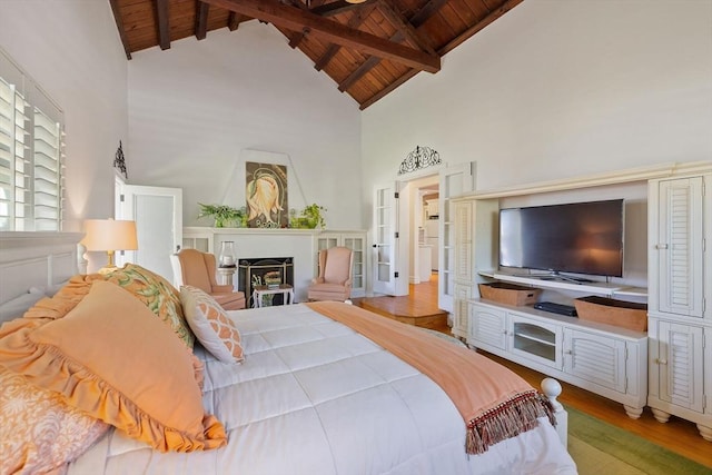 bedroom featuring wood ceiling, high vaulted ceiling, wood finished floors, a fireplace, and beam ceiling