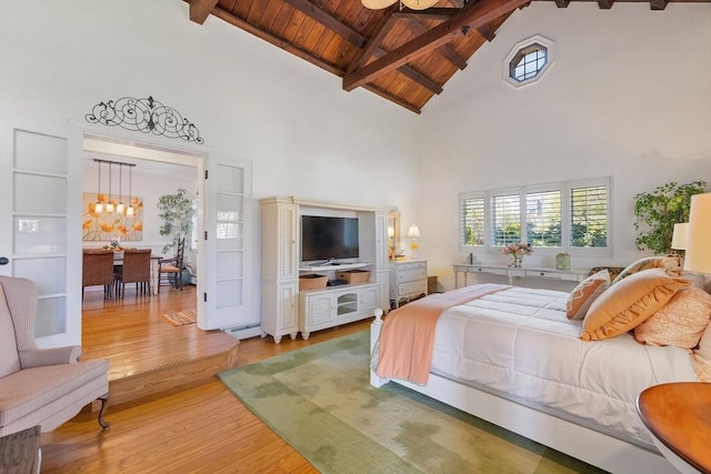 bedroom with light wood-style floors, wood ceiling, an inviting chandelier, and high vaulted ceiling