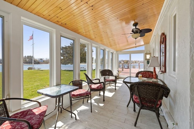 sunroom / solarium with a water view and ceiling fan