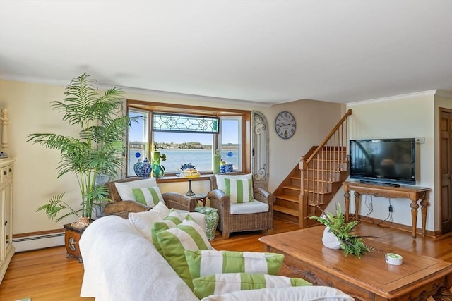 living room with stairway, crown molding, baseboard heating, and light wood-style floors