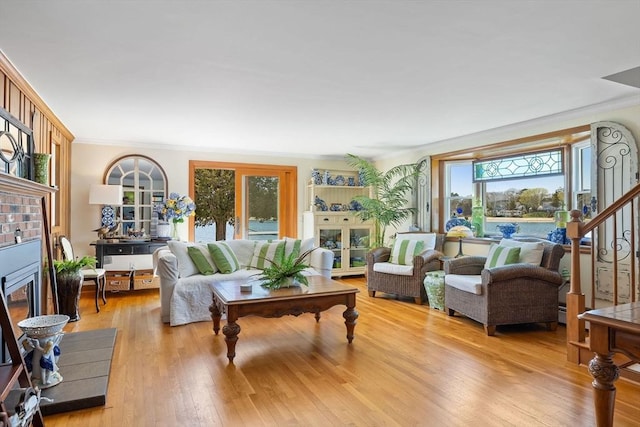 living room featuring a healthy amount of sunlight, crown molding, and a glass covered fireplace
