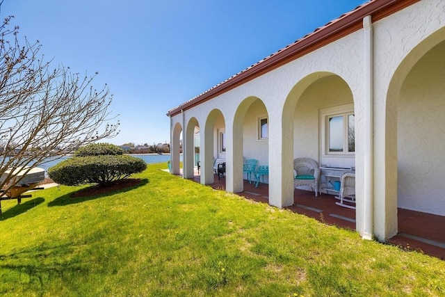view of yard with a water view and a patio