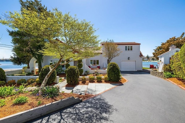 view of front of house featuring a water view, driveway, and a garage