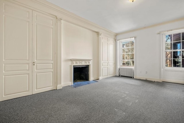 unfurnished living room with radiator, carpet, a fireplace with flush hearth, and ornamental molding