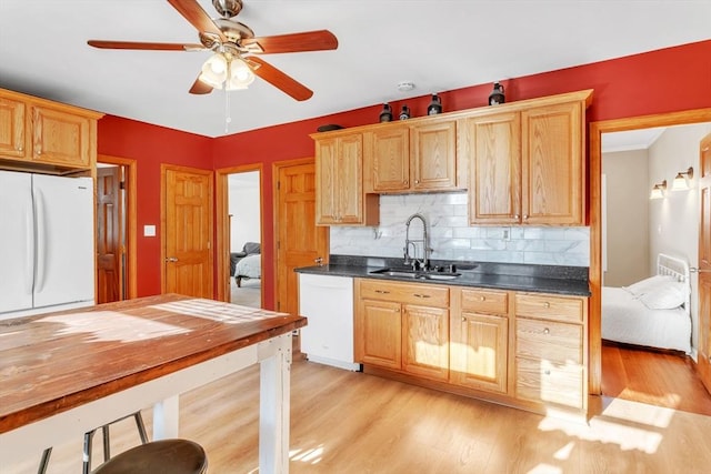 kitchen featuring sink, white appliances, light hardwood / wood-style flooring, ceiling fan, and decorative backsplash