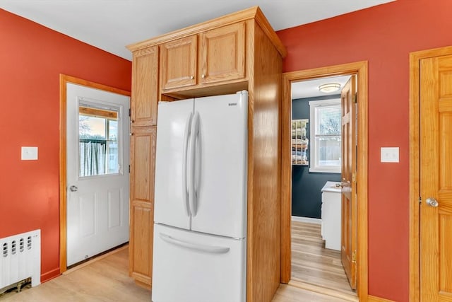 kitchen featuring light hardwood / wood-style flooring, light brown cabinets, white refrigerator, plenty of natural light, and radiator heating unit