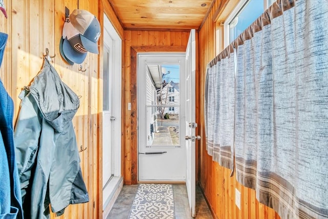 doorway with wood ceiling and wooden walls