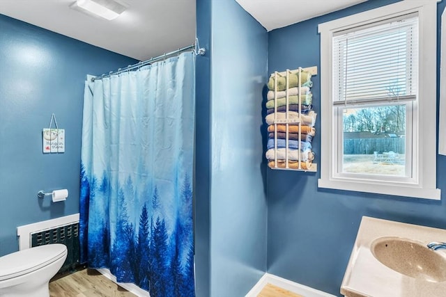 bathroom with toilet, radiator heating unit, vanity, a shower with shower curtain, and hardwood / wood-style flooring