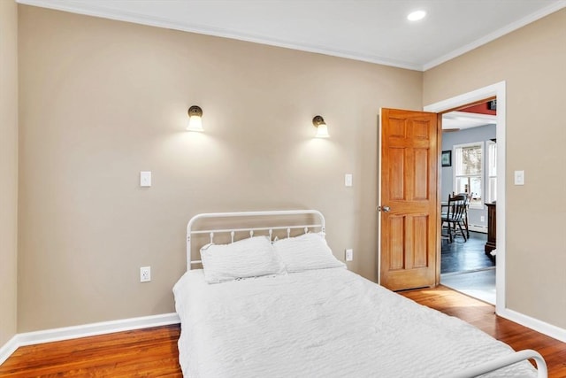 bedroom featuring wood-type flooring and ornamental molding