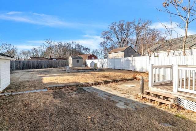 view of yard featuring a wooden deck and a storage shed