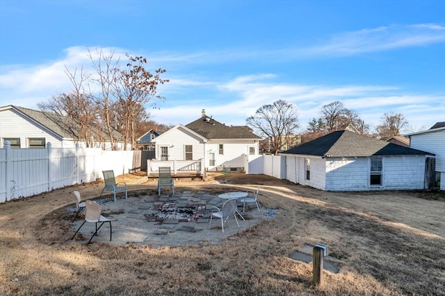 rear view of property featuring a wooden deck and a fire pit