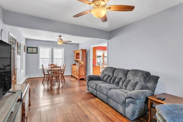 living room featuring hardwood / wood-style flooring, ceiling fan, and baseboard heating