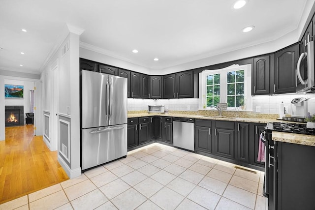 489 Main St, Acushnet, MA 02743 - kitchen with appliances with stainless steel finishes, light tile patterned floors, backsplash, crown molding, and dark cabinetry