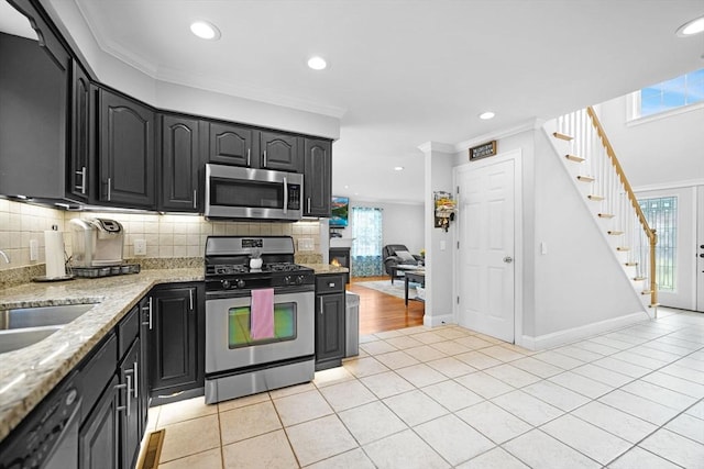 489 Main St, Acushnet, MA 02743 - kitchen featuring stainless steel appliances, crown molding, backsplash, light stone countertops, and dark cabinetry