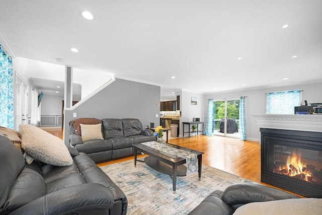 489 Main St, Acushnet, MA 02743 - living area featuring wood finished floors, a glass covered fireplace, ornamental molding, recessed lighting, and stairs