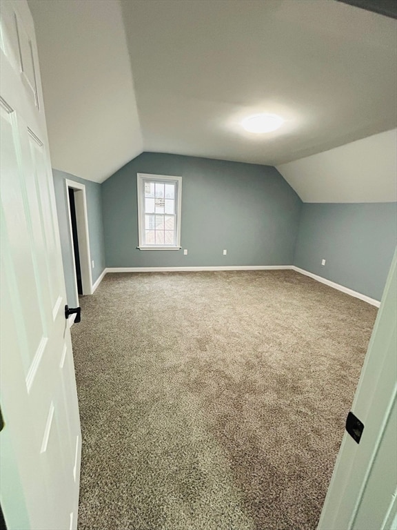 bonus room with carpet floors and vaulted ceiling