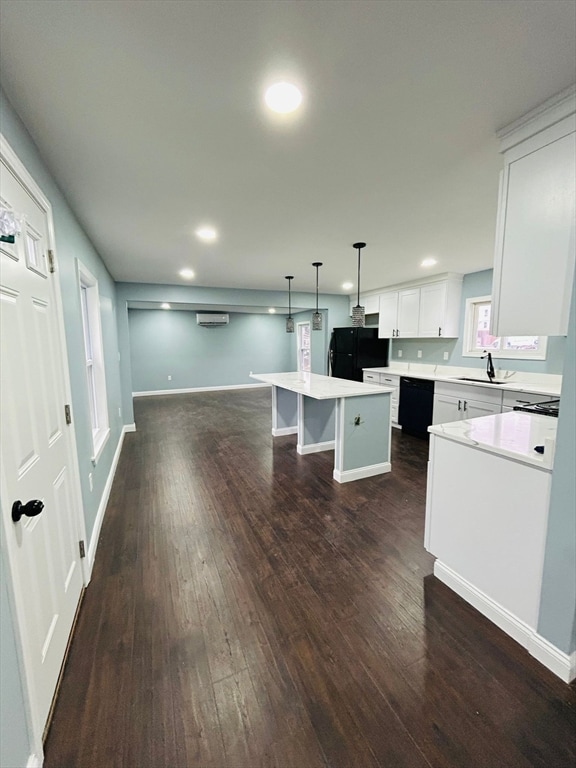 kitchen with a center island, hanging light fixtures, dark hardwood / wood-style floors, white cabinets, and black appliances