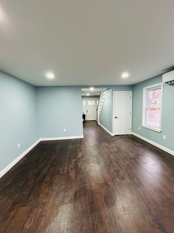 interior space with an AC wall unit and dark hardwood / wood-style flooring