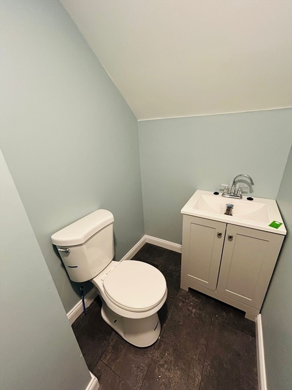 bathroom with vanity, lofted ceiling, and toilet