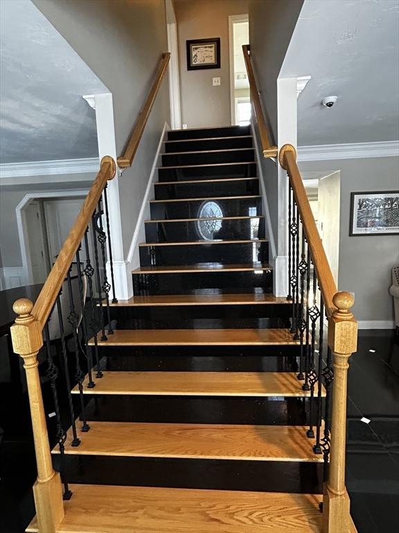 staircase with crown molding and hardwood / wood-style flooring