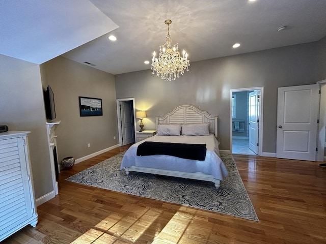 bedroom featuring hardwood / wood-style flooring, a chandelier, and ensuite bathroom