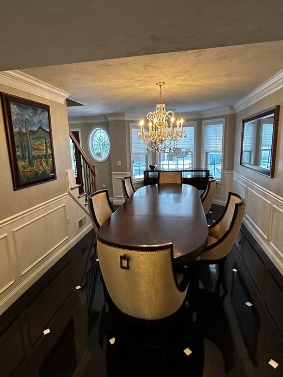 dining space with a notable chandelier, plenty of natural light, and ornamental molding